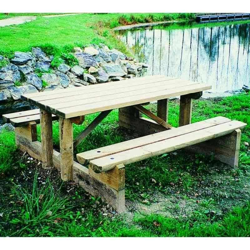 Table en bois avec bancs intégrés au bord d'un étang